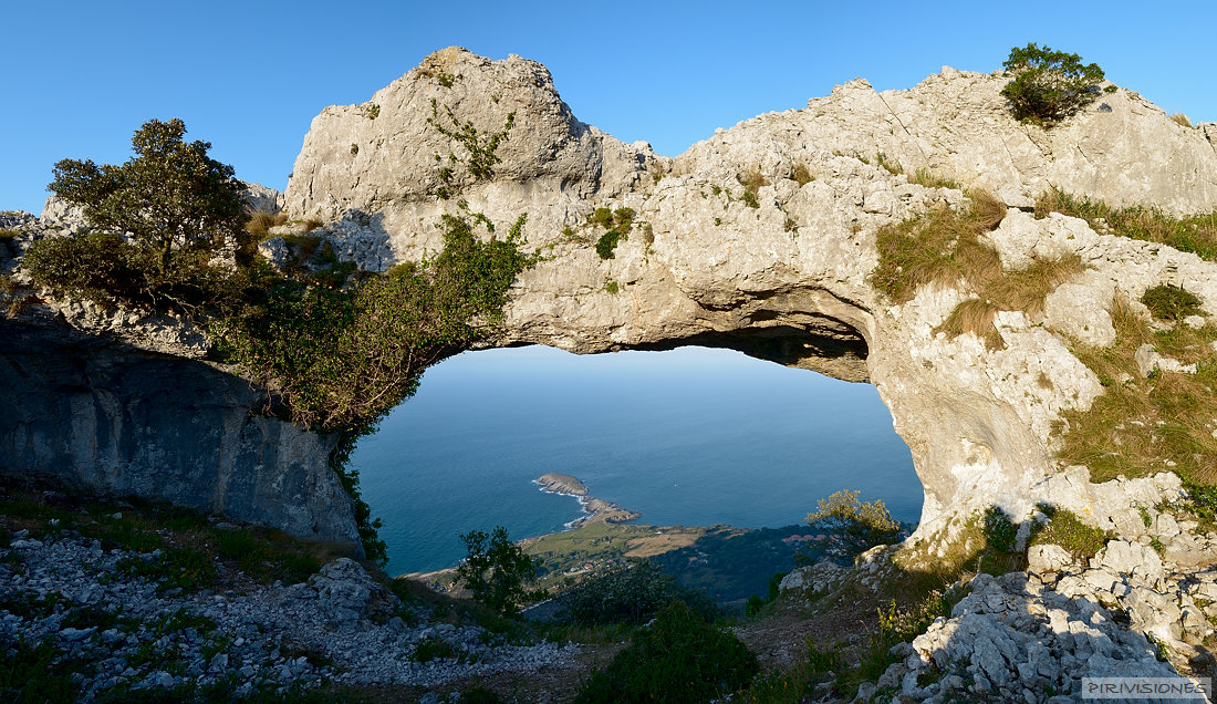 pirivisiones El arco natural geológico occidental de los dos que forman los Arcos del LLanegro también conocidos como Ojos del Demonio. A lo lejos el Cabo Cebollero, o Punta de Sonabia llamada por a