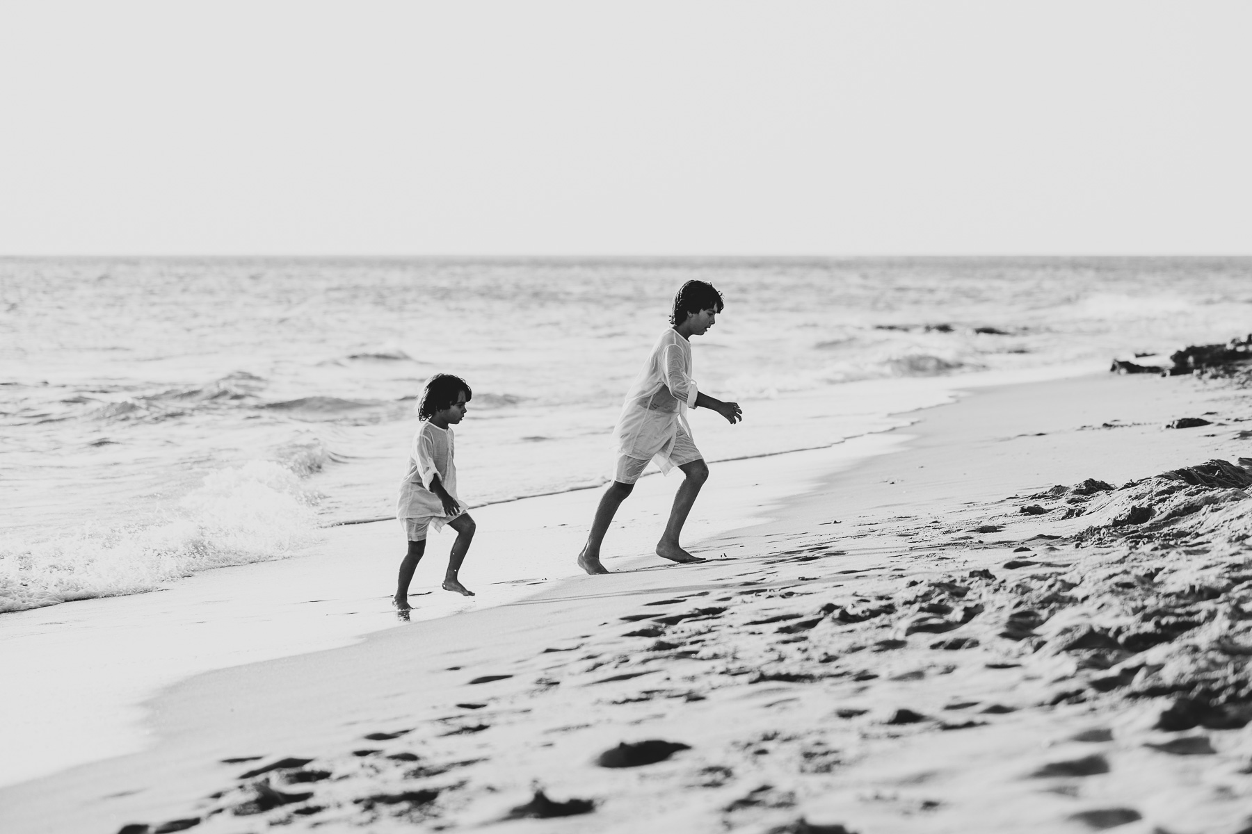 2 niños vestidos de blanco jugando en la playa La Barrosa. Foto Alba 14/10/2022