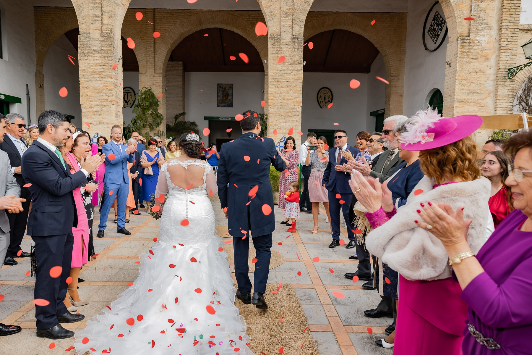Novios entrando al convite rodeados de invitados. Hacienda Torre de las Arcas. Boda en Sevilla