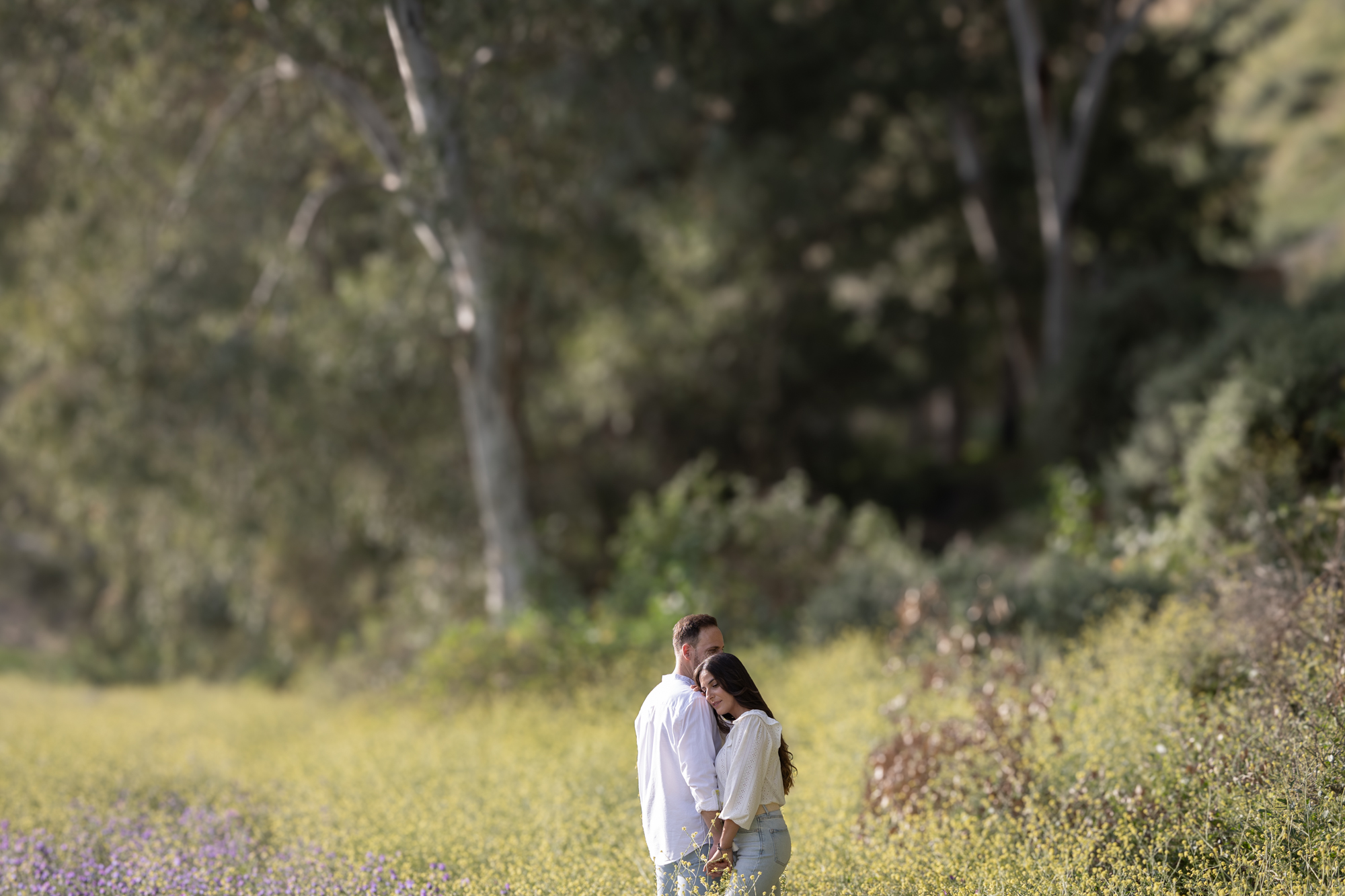 Foto artística de Lidia y Daniel en un camplo repeltos de flores. Sesión de fotos en Cádiz