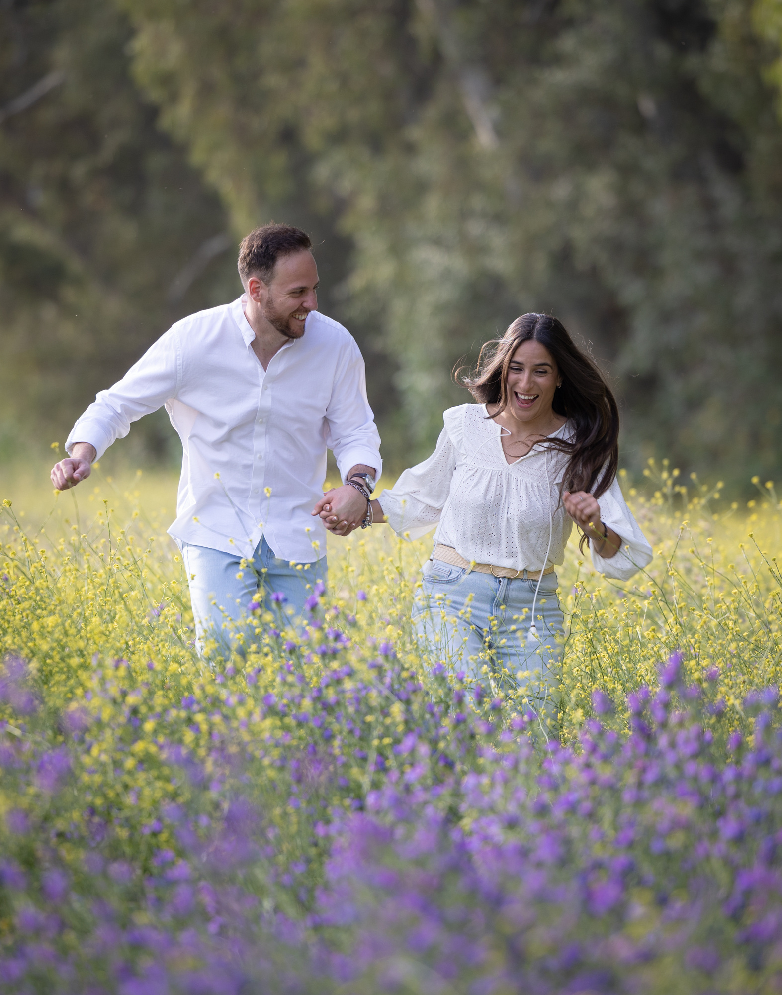 Novios corriendo por el campo, preboda llena de alegría y amor