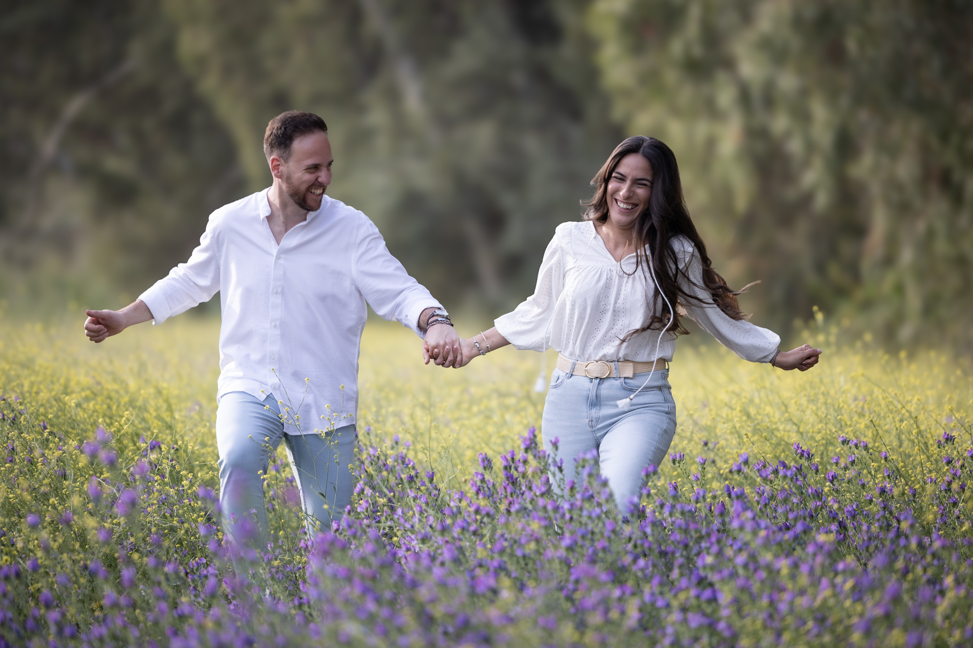 Novios corriendo por el campo, preboda llena de alegría y amor
