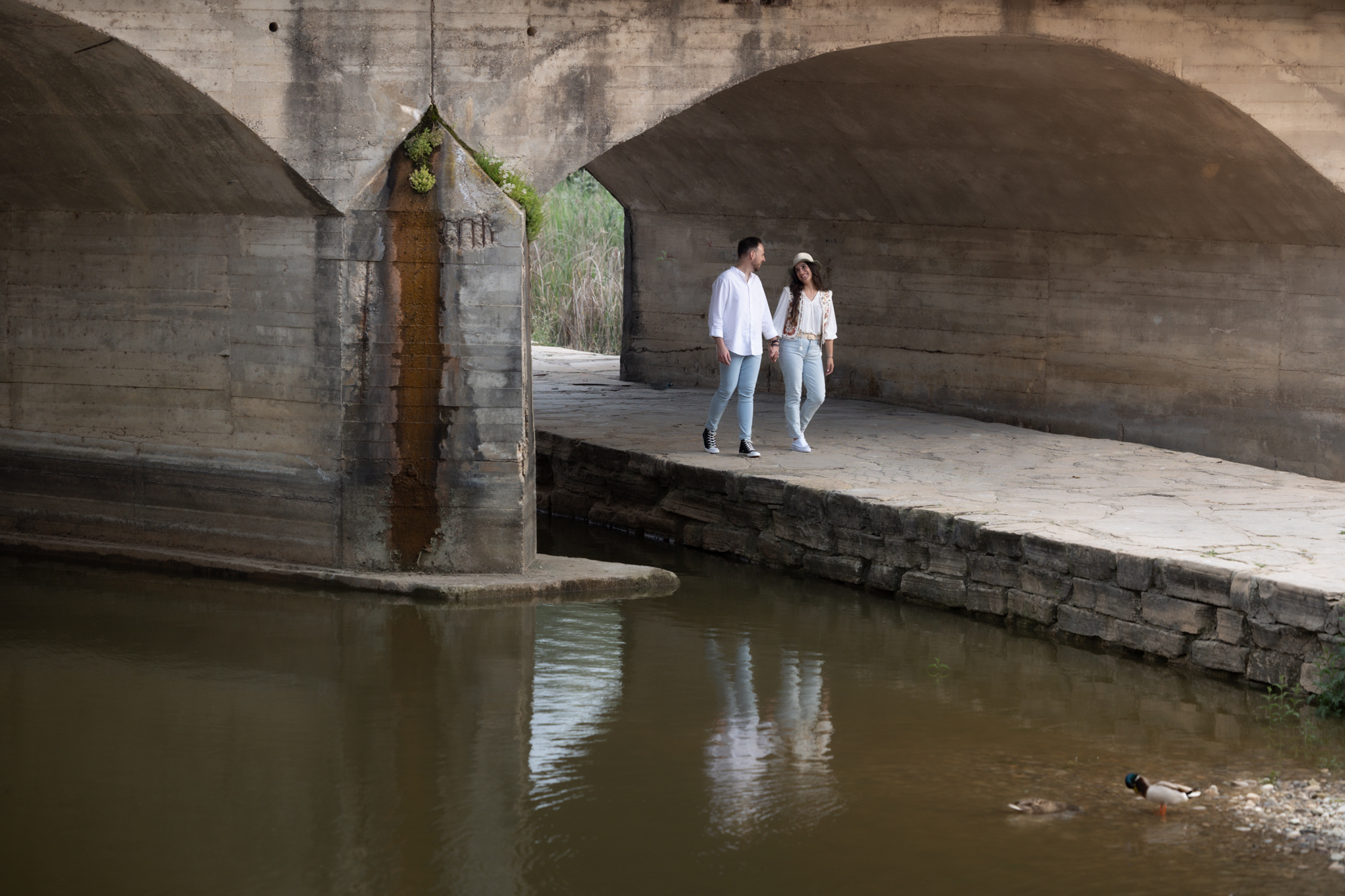 Novios pasean bajo un puente. sesión Peboda en Arcos (Cádiz)