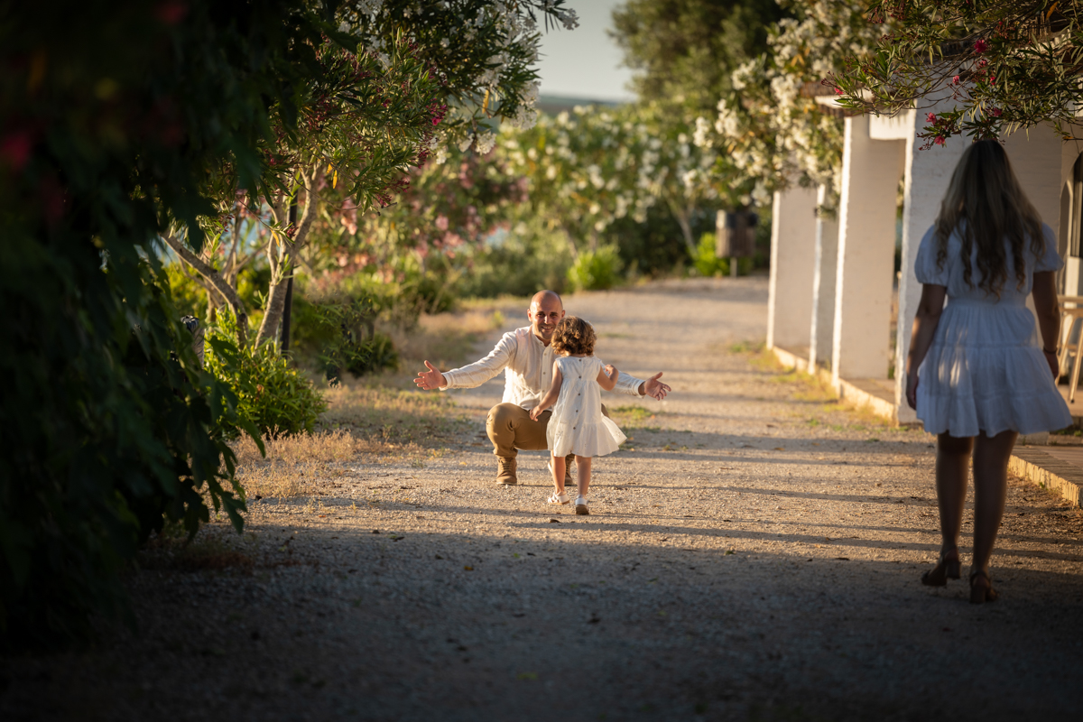 Un padre abre los brazos para recibir a su niña pequeña que corre hacia el