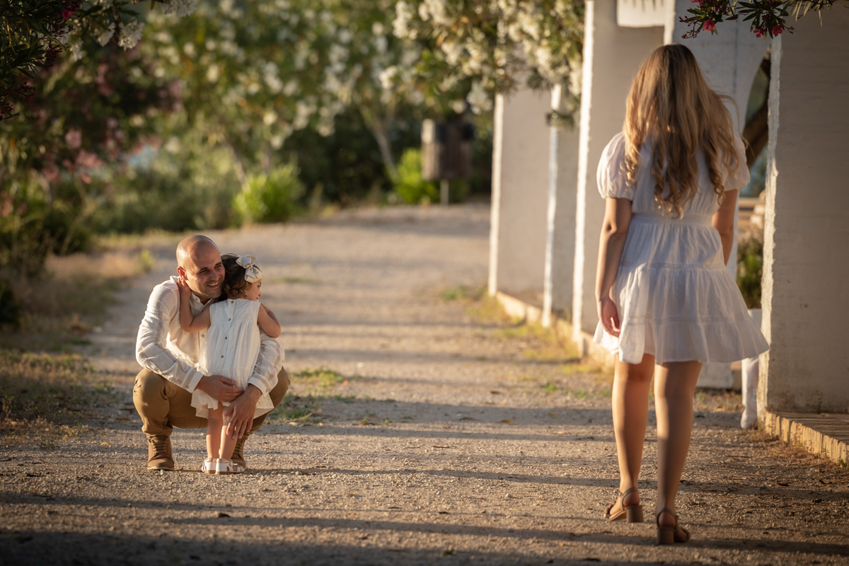 Padre agachado abraza a su hija de dos años
