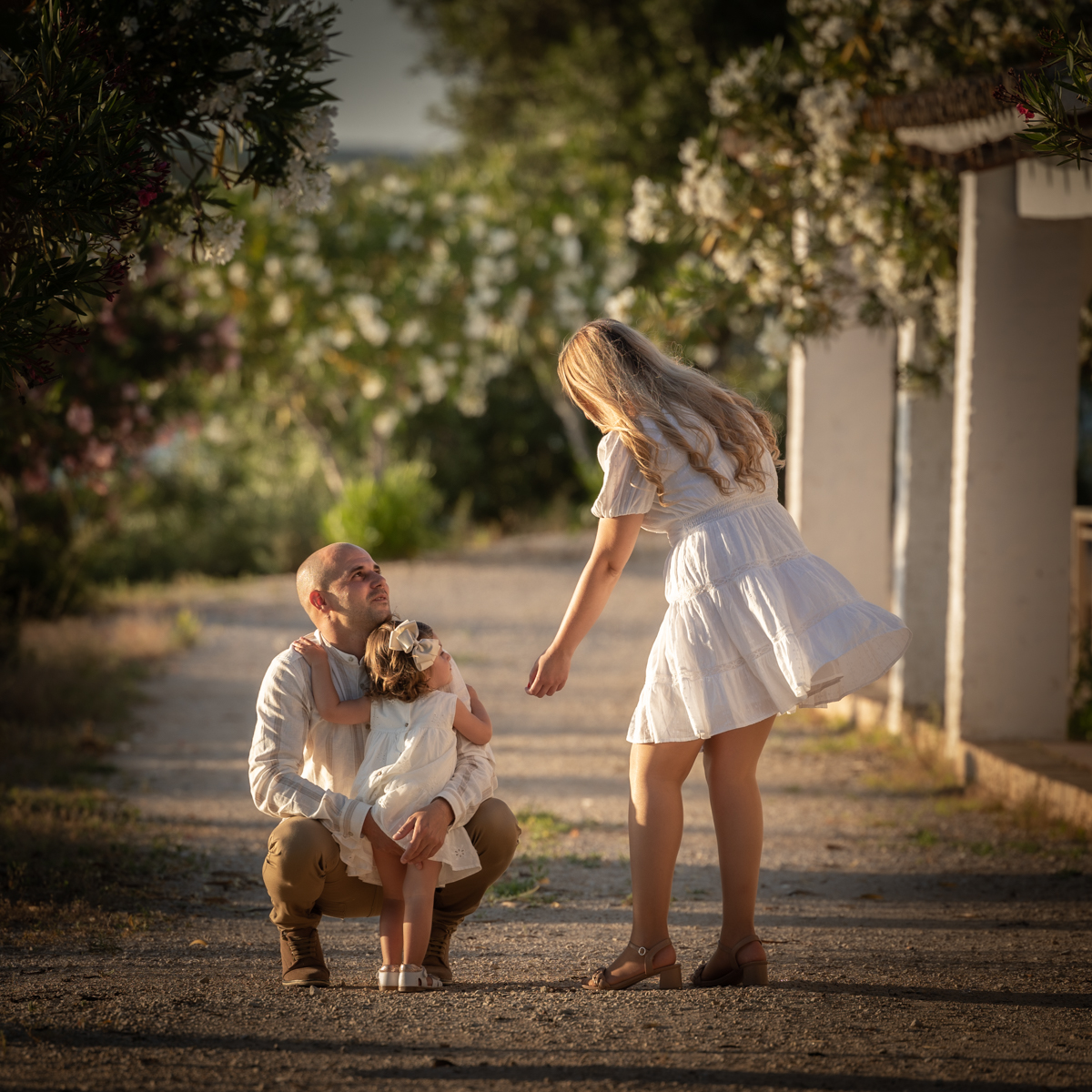 hombre, una mujer y una niña posan en una sesión de fotos en el campo