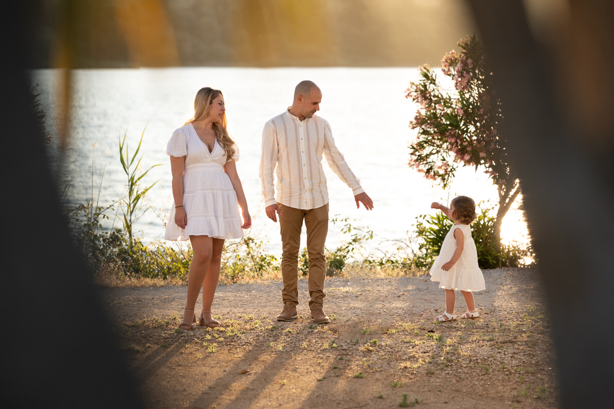 Familia compuesta por hombre, mujer, niña pequeña durante la sesión de fotos en familia