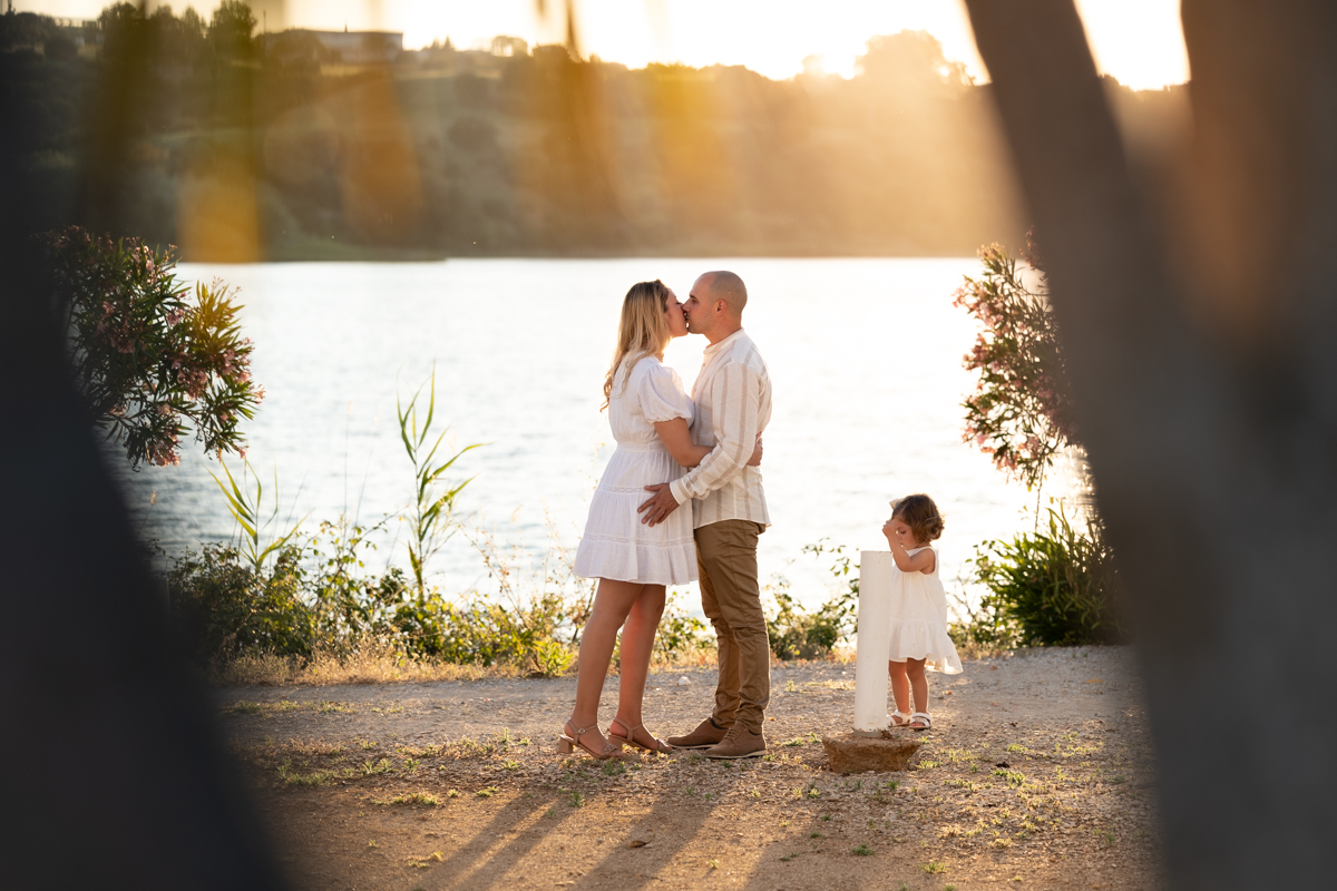 Familia compuesta por hombre, mujer, niña pequeña durante la sesión de fotos en familia
