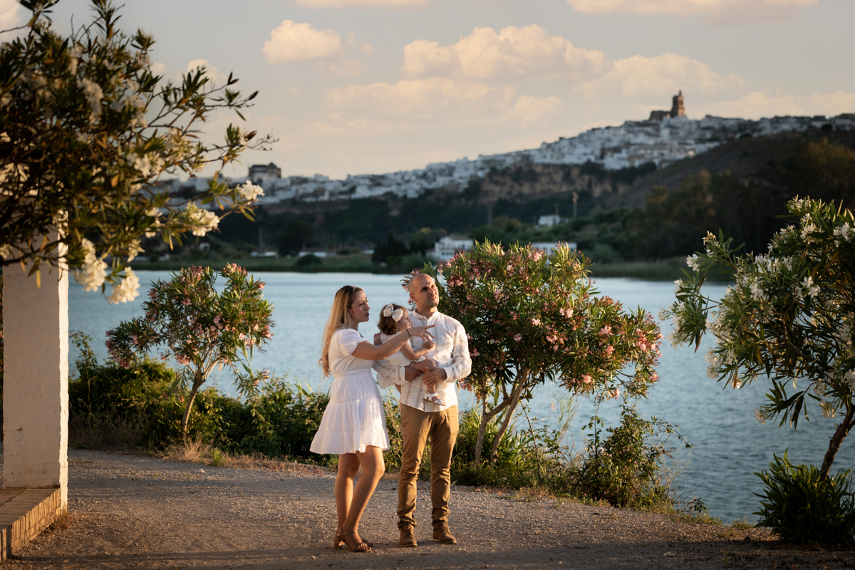 Familia compuesta por hombre, mujer, niña pequeña durante la sesión de fotos en familia
