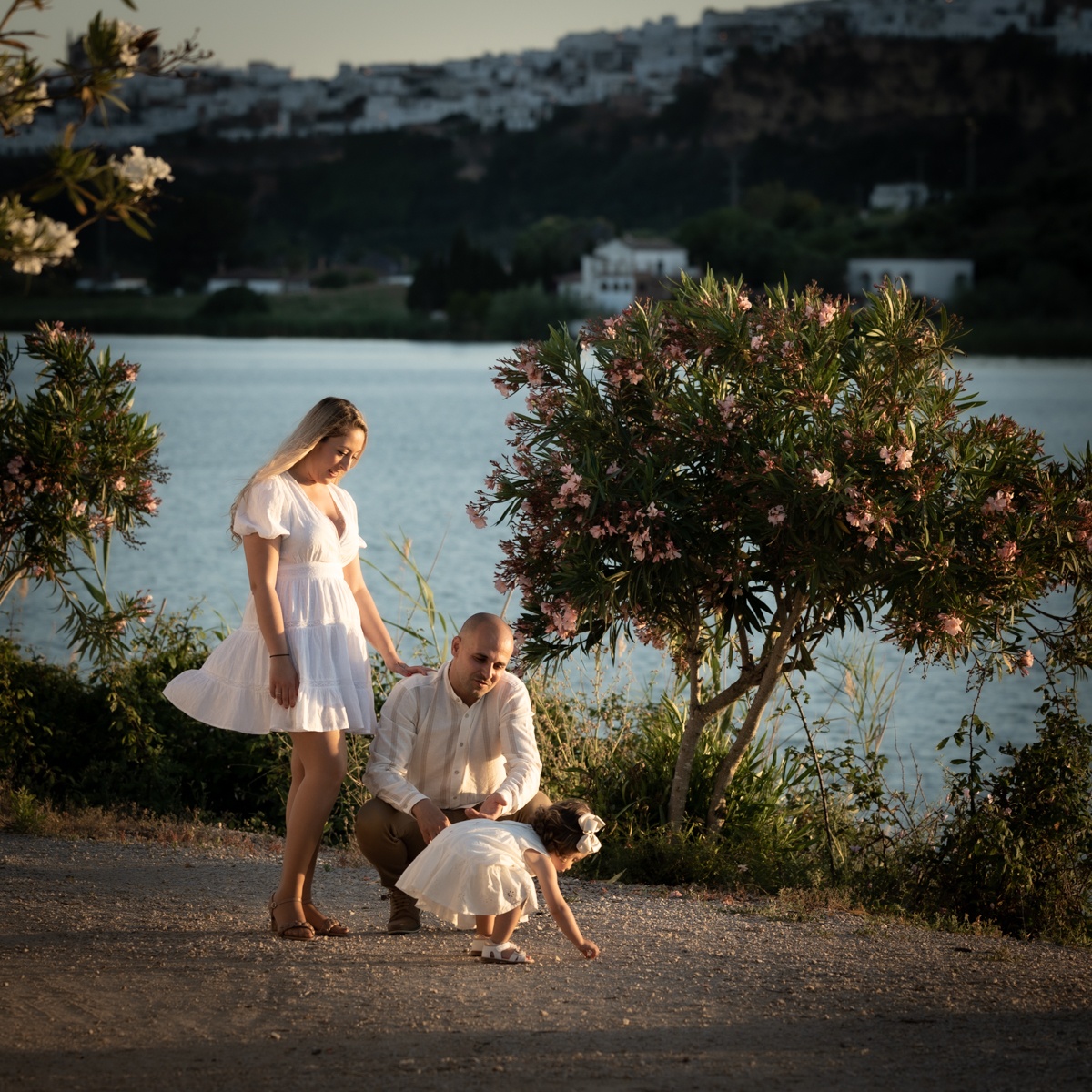Familia compuesta por hombre, mujer, niña pequeña durante la sesión de fotos en familia