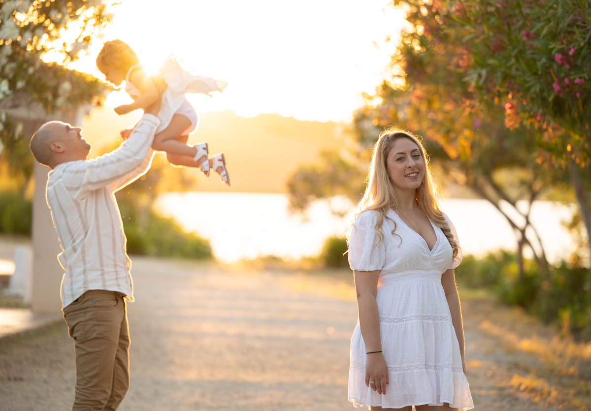Familia compuesta por hombre, mujer, niña pequeña durante la sesión de fotos en familia