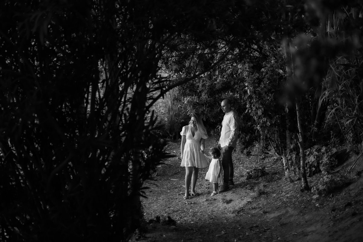 Hombre, mujer, niña pequeña, sesión fotográfica en blanco y negro junto al lago de Arcos