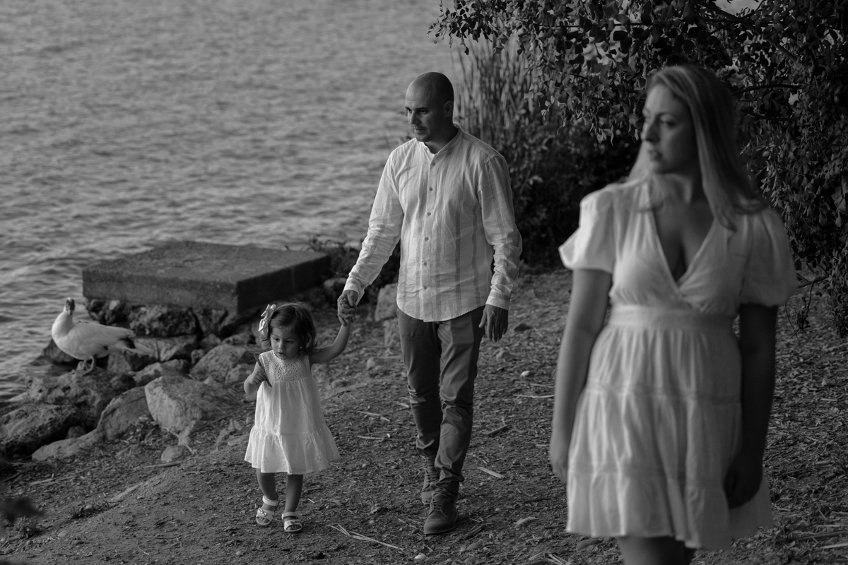 Hombre, mujer, niña pequeña, sesión fotográfica en blanco y negro junto al lago de Arcos