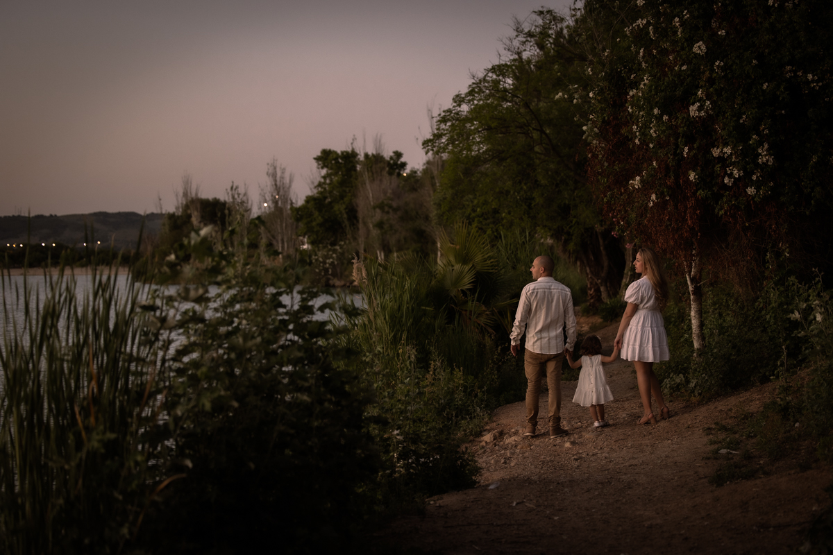 Hombre, mujer, niña pequeña, sesión fotográfica en familia junto al lago de Arcos