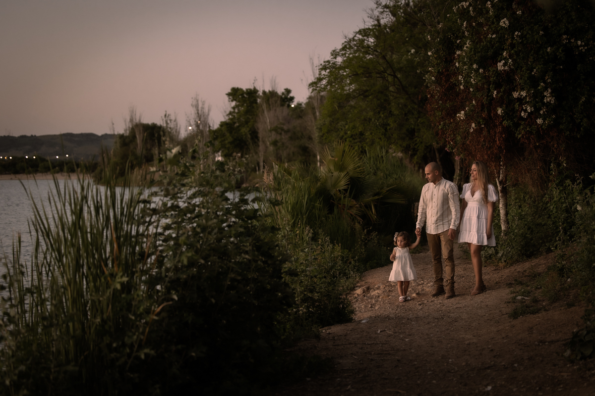 Hombre, mujer, niña pequeña, sesión fotográfica en familia junto al lago de Arcos