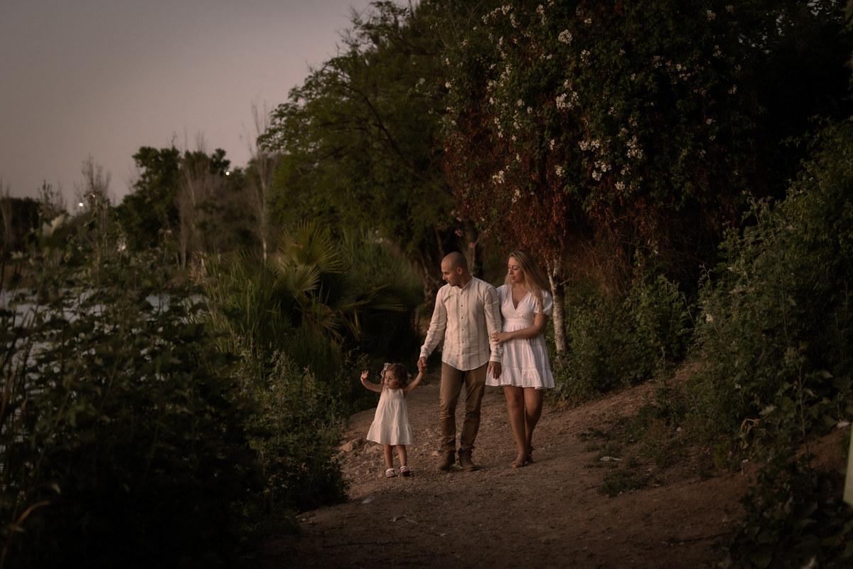Hombre, mujer, niña pequeña, sesión fotográfica en familia junto al lago de Arcos