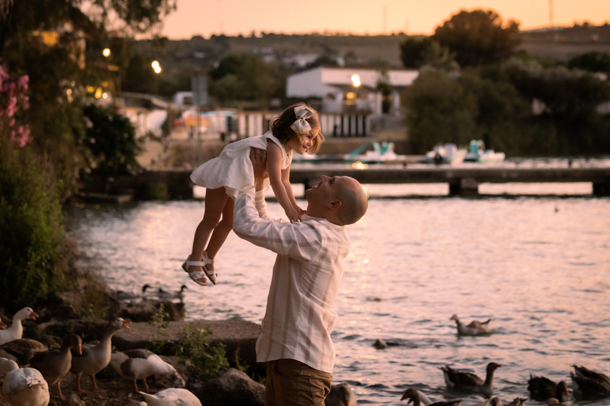 Padre levanta en brazos a su hija pequeña junto al lago de Arcos de la Frontera