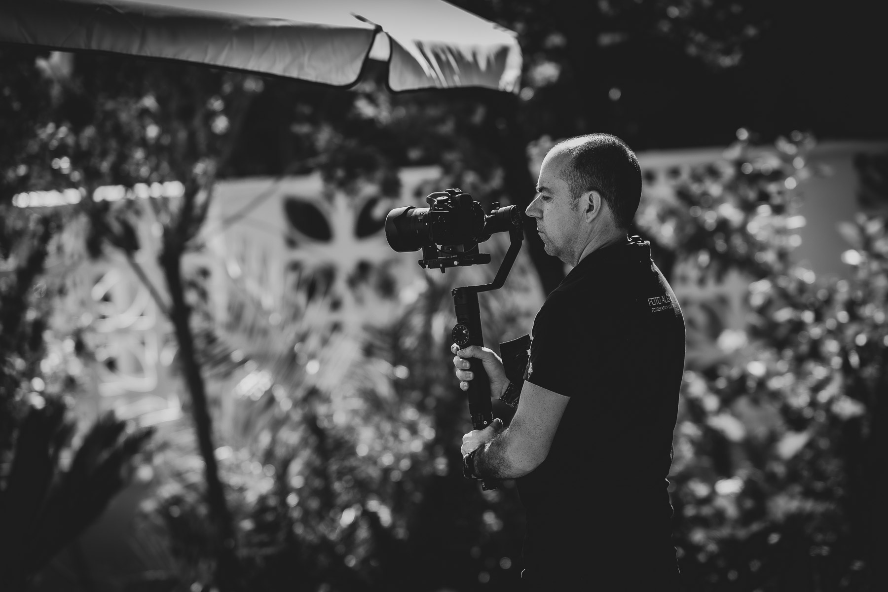 Blanco y negro de un cámara de video de Foto Alba durante la Celebración de la Primera Comunión de María José, El Bosque (Cádiz)