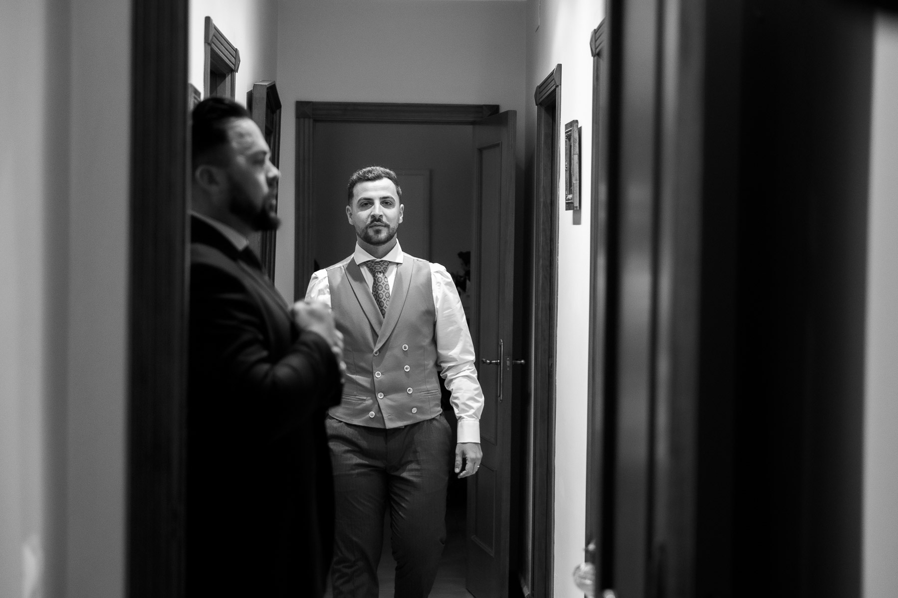 Blanco y negro del hermano caminado por el pasillo de la casa