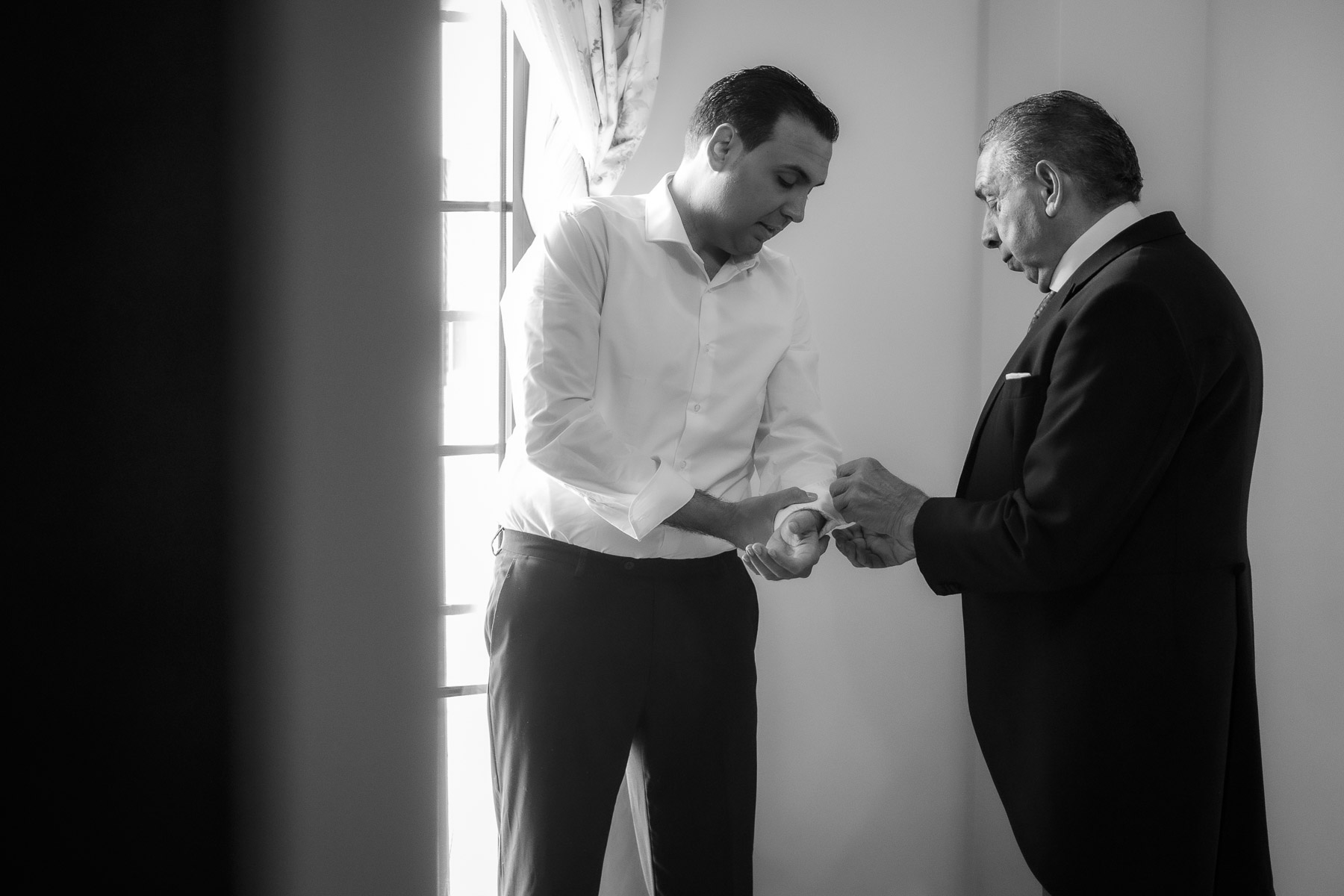 blanco y negro padre de Manuel ayuda a colocarse los gemelos