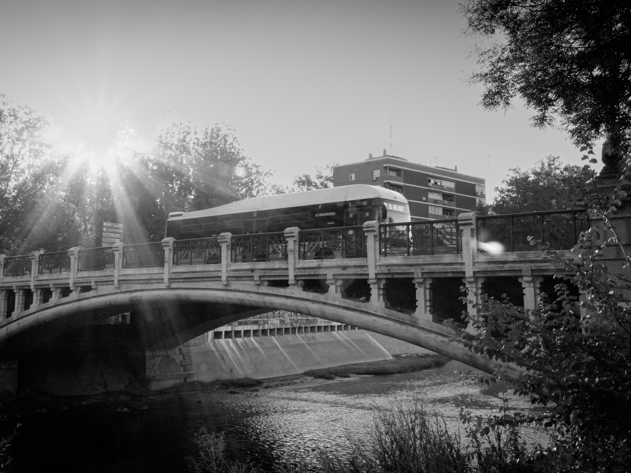 Puente sobre un río con autobús pasando