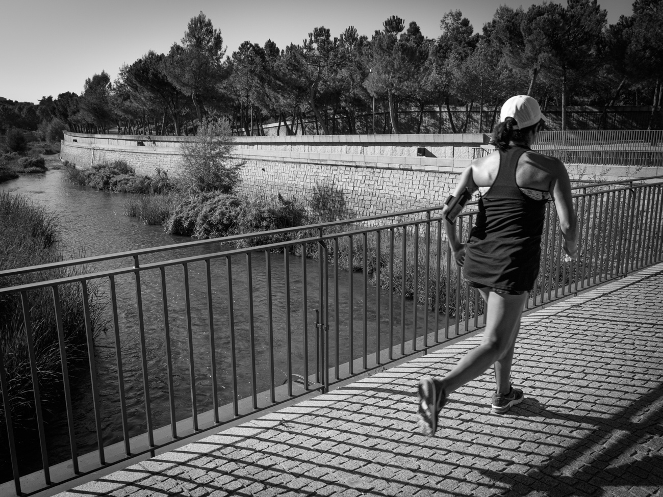Mujer corriendo por un puente sobre un río