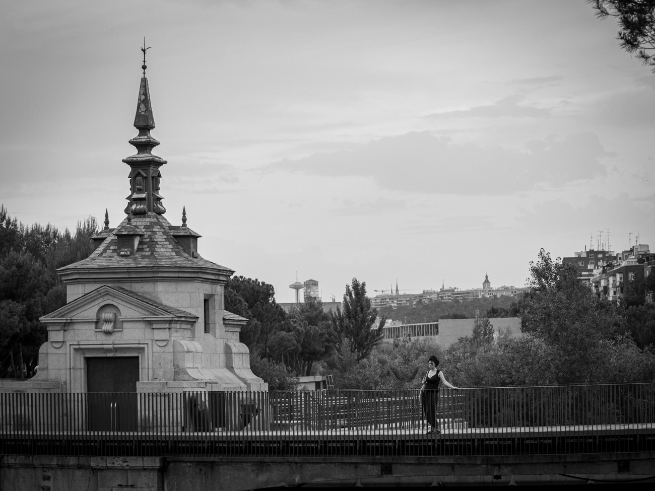 Persona contemplando paisaje en un puente sobre un río
