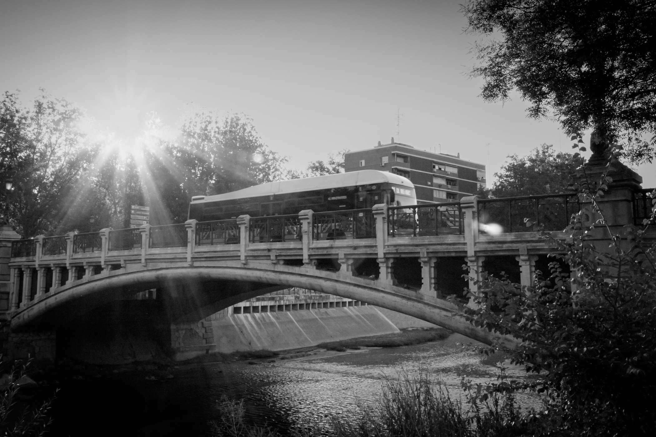 Puente sobre un río con autobús pasando