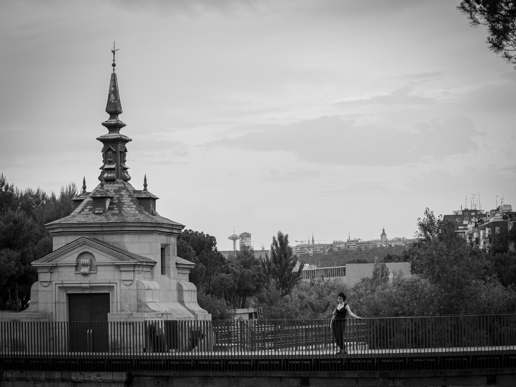 Persona contemplando paisaje en un puente sobre un río