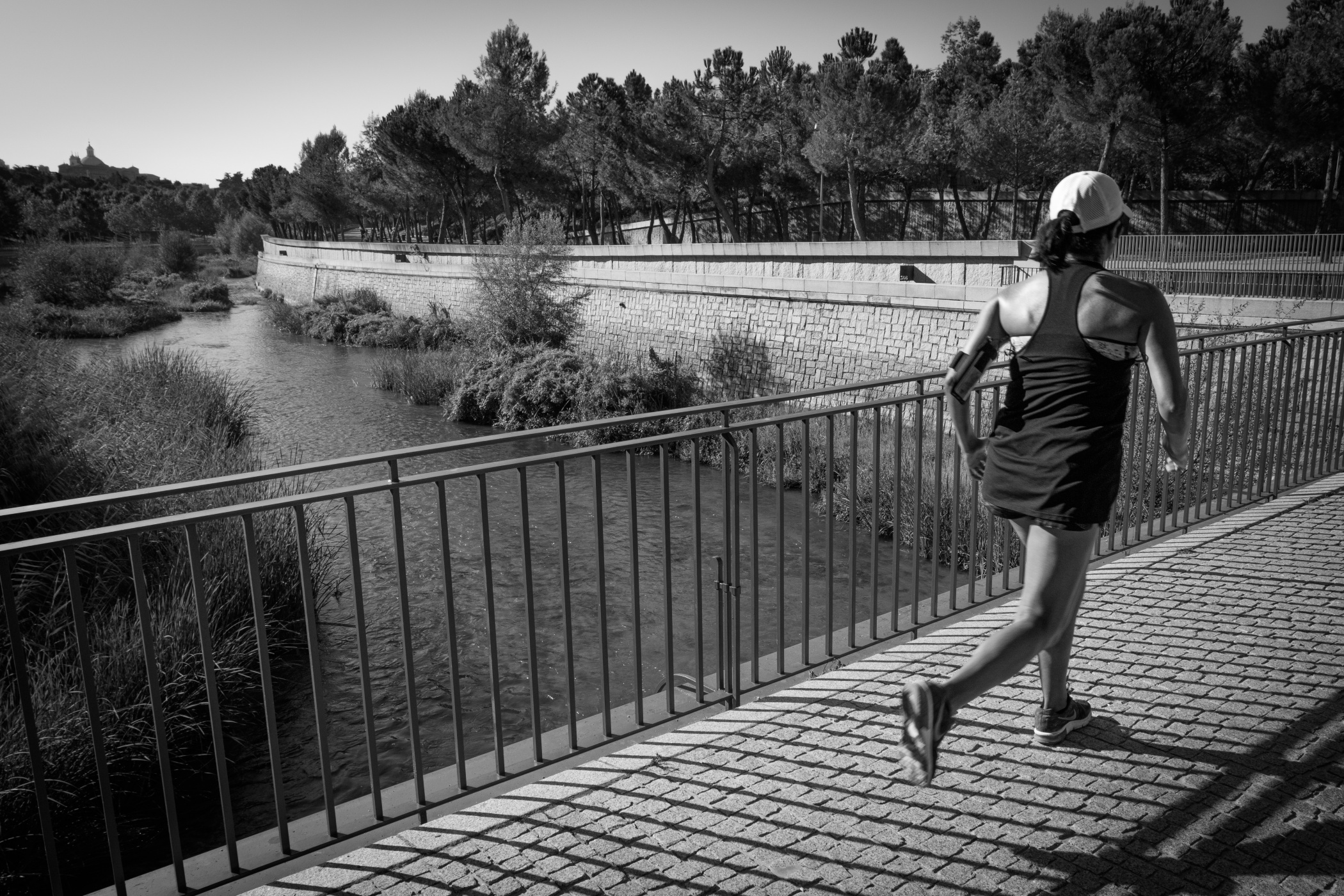 Mujer corriendo por un puente sobre un río